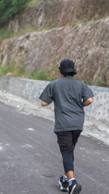 Kırsal bir yolda koşan kişi