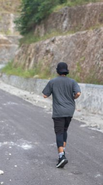 Adam yolda koşuyor.