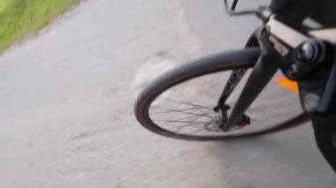 Asfaltlı bir yolda bisiklet çarkı hareket ediyor