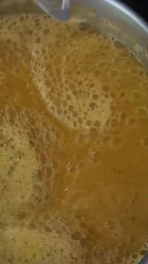 Evde çorba yapmak için sebzeleri el blendırıyla karıştırmak. Kremalı sebze saflığı mutfak hazırlığını, sağlıklı yemek yapmayı ve pratik pişirme kavramlarını gösteriyor..