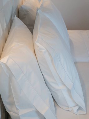 Düzenli yapılmış bir yatakta iki büyük beyaz yastığın ayrıntıları. Modern bir ev ya da otelde rahatlık, rahatlık ve minimalist iç dizayn. İnsanlar yok, saf dinlenme, bakım ve kalite kavramı..