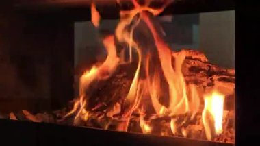 Soğuk kış akşamları çağdaş bir oturma odasında, parlayan alevler ve odunlarla yanan modern serbest ahşap soba termal konfor sağlar.