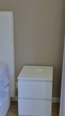 Gerçek bir yatak odasında kırışık çarşaflar ve kıyafetlerle dağınık, dağınık, dağınık bir ev ortamını ve günlük yaşantısını gösteren çift kişilik bir yatak..