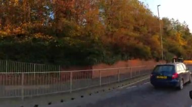 Güneşli bir günde İngiltere 'nin Şehir Caddelerinde Şehir Sürüşü. Otomobil Bağlı Geniş Açı Kamera Hızlandırılmış Zaman Hızlandırmalı Görüntü Kısmen Bulutlu Gün ve çoğunlukla güneşli ve Soğuk 5 Kasım 2025 'te çekildi. İngiltere 'nin İngiliz şehrinde yakalandı.