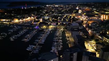 Işıklandırılmış Central Plymouth İHA Turu Yüksek Açılı Zaman Hızlandırmalı Görüntüleri Gece yarısı İngiltere Birleşik Devletleri Binaları 'nın Aydınlanmış Ana Caddeleri üzerinde. 28 Haziran 2025.