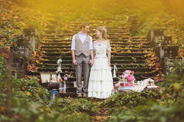 Les mariés se tiennent près des marches en pierre entourées d'un décor de mariage — Photo