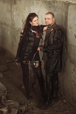 Raider man and woman in leather costume with a bow at post-apocalyptic world. clipart