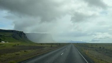Sonsuz asfalt yolu İzlanda 'da dramatik bulutlu gökyüzünde kayboluyor. Yüksek kalite 4k görüntü