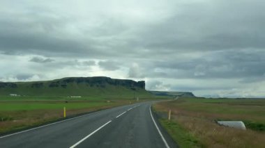 Uzak İzlanda Ovası 'ndan uzak dağlara doğru kıvrımlı otoyol. Yüksek kalite 4k görüntü