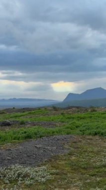 İzlanda 'daki dramatik Bulutlu Gökyüzü' nün altındaki Yeşil Çayırda Çakıl Yolu. Yüksek kalite 4k görüntü