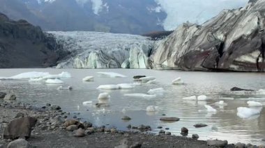 İzlanda 'da Rocky Shores ile Silty Lagoon' daki Buzdağları ve Buzul Dili. Yüksek kalite 4k görüntü