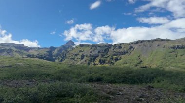 Wide Rolling Green Hills with Distant Mountains in Icelandic Landscape. High quality 4k footage