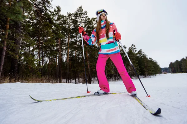 Sportliches Mädchen beim Skifahren in heller Kleidung — Stockfoto