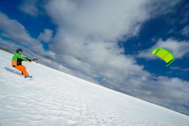 Uçurtma sporcu bir snowboard üzerinde çalışır