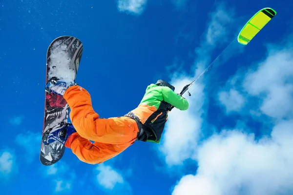 El deportista en una tabla de snowboard corre cometa — Foto de Stock