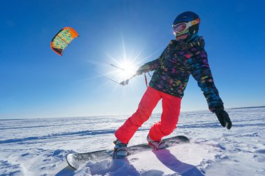 Uçurtma sporcu bir snowboard üzerinde çalışır