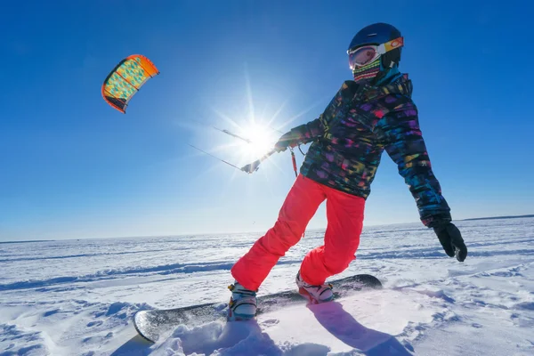 El deportista en una tabla de snowboard corre cometa — Foto de Stock