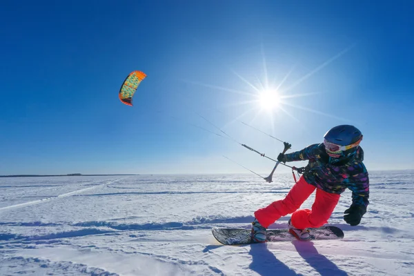 Der Sportler auf dem Snowboard fährt Drachen — Stockfoto