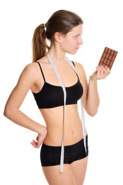 Sportswoman with chocolate. The problem and the temptation while