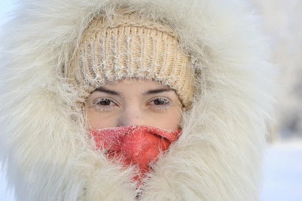 The girl in a fur coat has frozen in the winter.