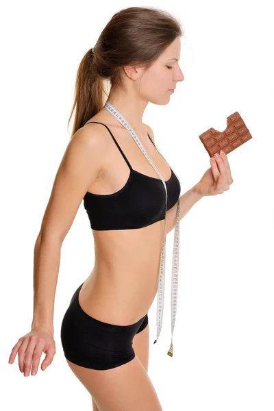 Sportswoman with chocolate. The problem and the temptation while — Stok fotoğraf