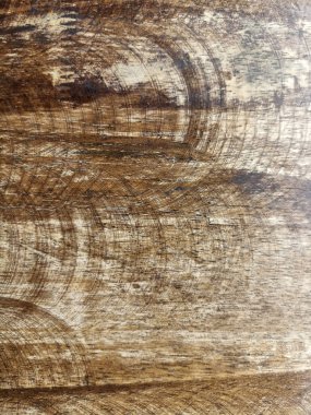 Yuvarlak zımparalama izleri olan aşınmış ahşap yüzey ve desenli tahıl kırsal sıcak estetik oluşturuyor.