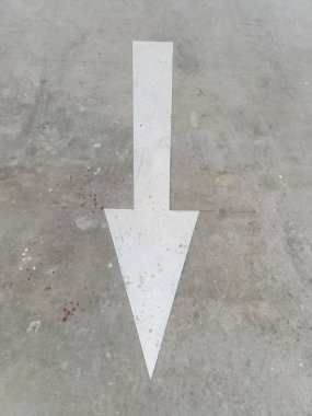 Beton zemine boyanmış beyaz yönlü ok öne bakan, aşınmış desenli minimum kentsel grafik