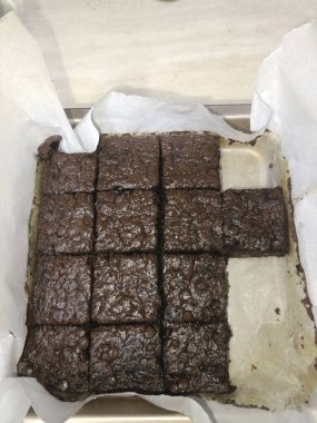 Çikolatalı kek tepsisi parşömen ve kesim kareleri ile fırınlanır, ev yapımı zengin bir tatlı ve parlak bir üst