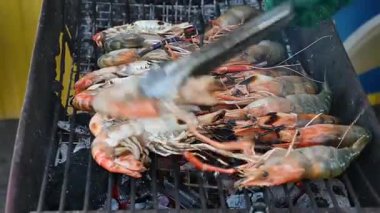 Izgara karides ızgara mangal mangal sokak yemekleri pişirme sahnesi şefin eli lezzetli yemek ve taze yemek hazırlıyor.