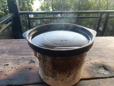 Çamur ocağı sıcak su buharı dışarıda pişiyor. Kil ocağı buharı yükselen geleneksel yemek pişirme kabı.