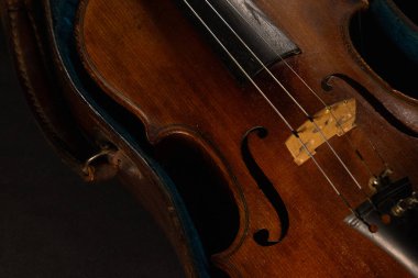 Eski keman siyah bir bezle kaplı bir masanın üzerine yerleştirilmiş.