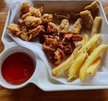 Kızarmış tavuk ve baharatlı kırmızı sosla dolu beyaz bir tabağın genel manzarası günlük yemek ya da lezzetli yemek için hazır..