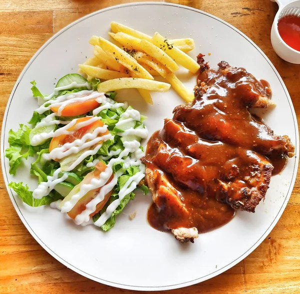 Sosla kaplanmış leziz ızgara tavuk, taze salata ve patates kızartması ile servis edilmiş. Yemek bloğun için iyi bir yemek..