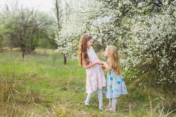 küçük kız güzel bahar gününde çiçek açan bahçesinde