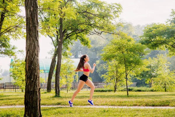 Mujer corriendo. Corredor femenina corriendo durante el entrenamiento al aire libre en un parque. —  Fotos de Stock