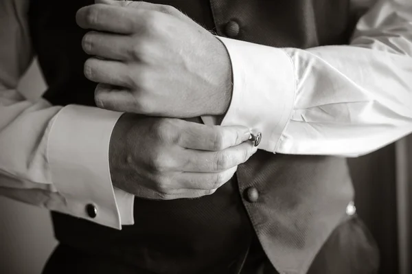 Erkekler gömlek ve kol düğmesi giyer.