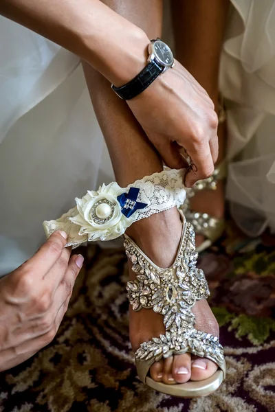 Bride putting on wedding garter