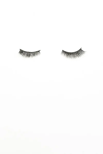 Pair of false eyelashes on white