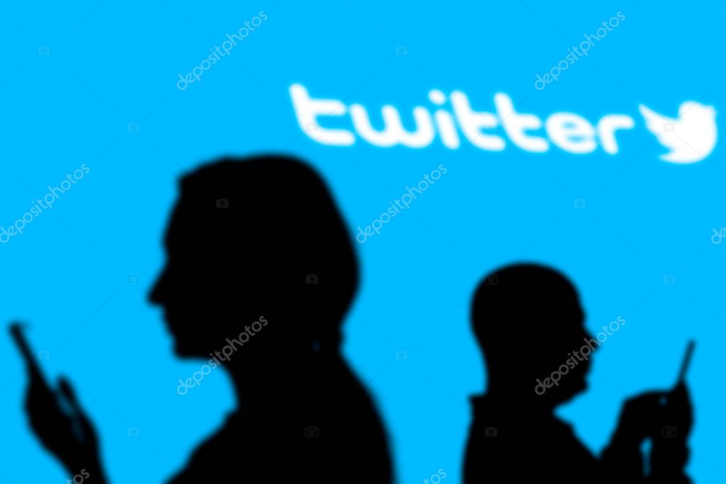 Tashkent, Uzbekistan - March 4, 2021: Silhouette of people over popular microblogging and social networking service - Twitter logologotype on a large screen