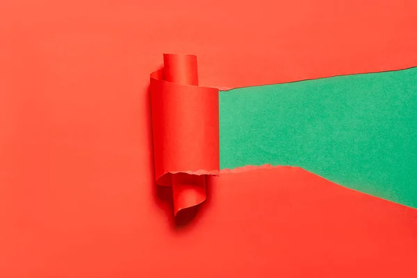 Vridna bit rött papper över grön bakgrund — Stockfoto