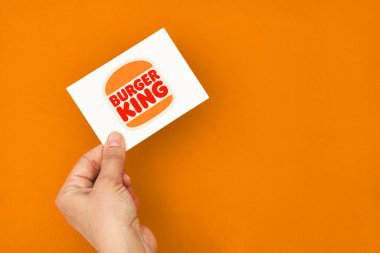 Elinde Burger King logosu olan bir kart var.