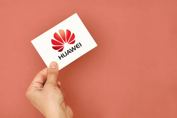 Το χέρι κρατά μια κάρτα με το λογότυπο Huawei — Φωτογραφία Αρχείου