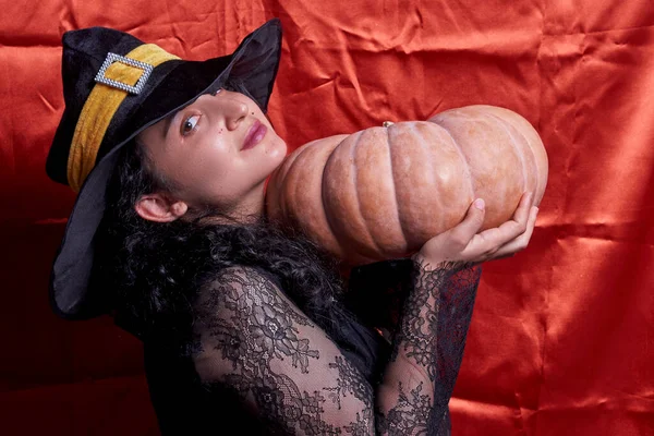 Halloween dáma na sobě čarodějnice pohár a drží velké halloween dýně — Stock fotografie