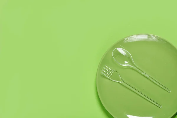 Зелена тарілка та пластикова виделка з ложкою — стокове фото
