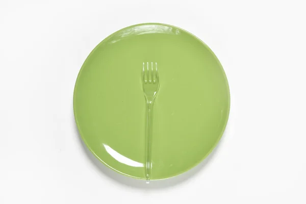 Zielona płyta i plastikowy widelec z łyżką — Zdjęcie stockowe