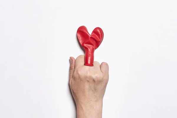 Fuck love. Middle finger and heart shape balloon —  Fotos de Stock