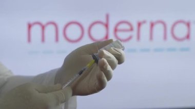 Tıp çalışanı, sağlık merkezinde yapılan büyük bir aşı sırasında Moderna aşısını hazırlıyor. Coronavirus 'a karşı aşı