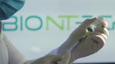 Sağlık görevlileri, sağlık merkezindeki büyük bir aşı sırasında Biontech aşısını hazırlayın. Coronavirus 'a karşı aşı