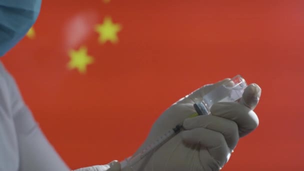 Un travailleur médical prépare l'injection du vaccin covid-19 contre le drapeau chinois — Video