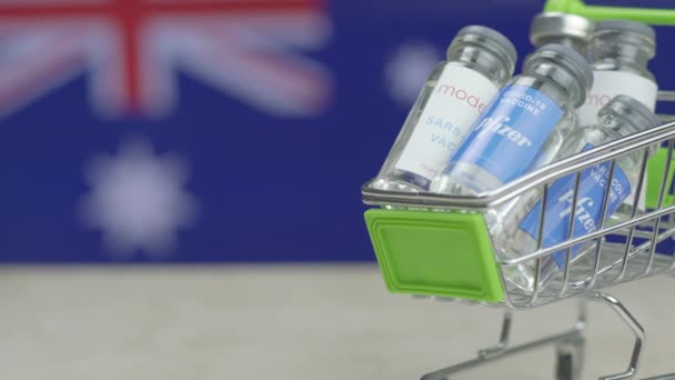 Carrinho de compras cheio de frascos de Covid-19 contra bandeiras nacionais de países — Vídeo de Stock